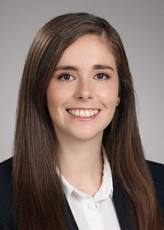 Bruna Gomes headshot. SHe is wearing a black blazer over a white collard shirt.