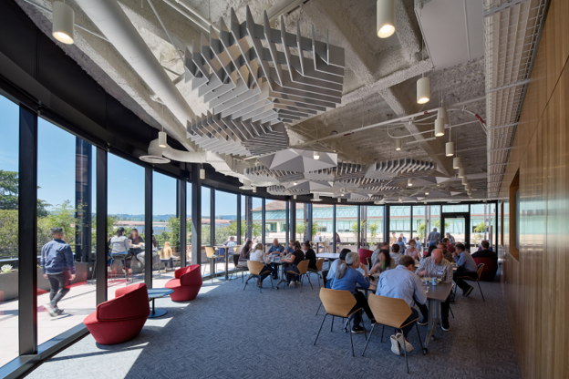 Inside the Stanford Computing and Data Science Building, people sitting at tables